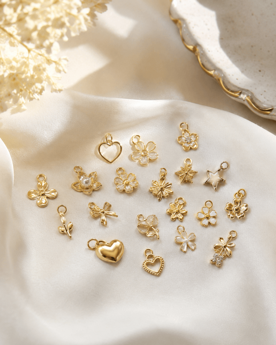 Small gold charms arranged on ivory silk